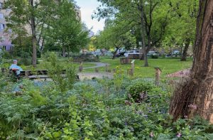 Übersicht PikoPark Erfurt mit buntem Blumenbeet. Frau sitzt entspannt und Natur genießend auf Bank